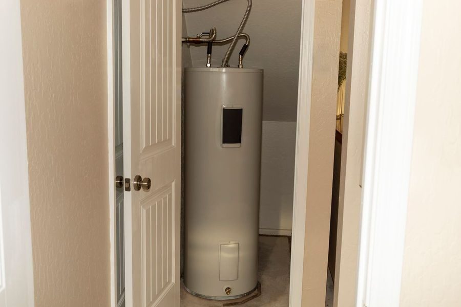 Standard storage tank water heater in a utility closet